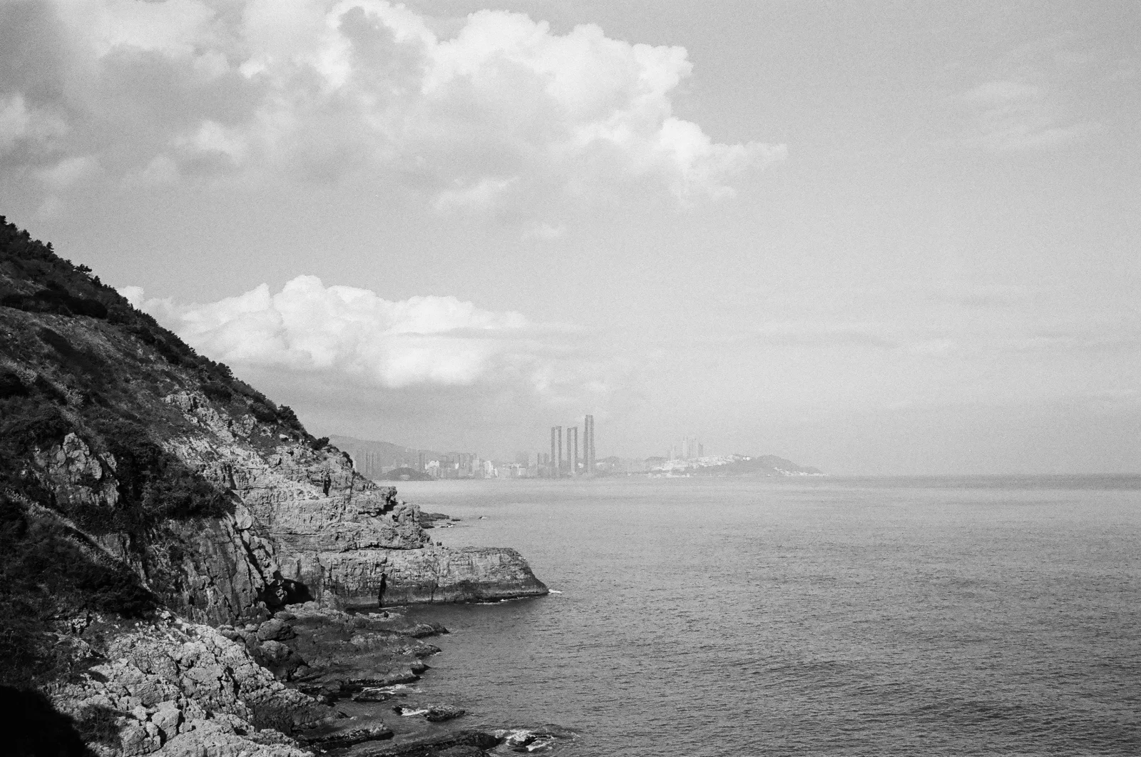 A black-and-white photograph of rocks and sea